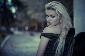 Naklejka premium purity, romantic scene, beautiful blond, fallen angel with black