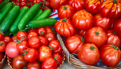 Red tomatoes and cucumbers in baskets