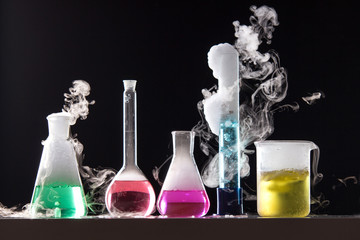 Glass in a chemical laboratory filled with colored liquid during - obrazy, fototapety, plakaty