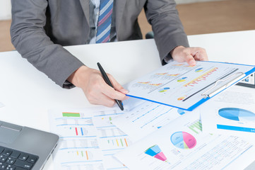 Businessman analyzing report on chart with laptop
