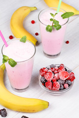 Frozen summer berries milkshakes on white wooden background