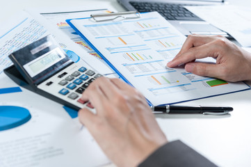 Businessman using calculator analyze report