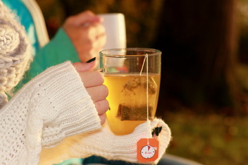 Daughter and mother drink tea in autumn park