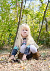 Adorable Little Girl Sitting on Forest Ground