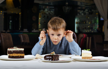Little boy mesmerised by an assortment of cakes