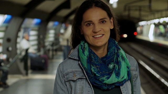 Woman smiling to the camera while waiting for metro, steadycam s