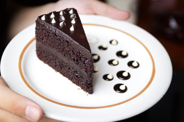 Hand on piece of chocolate cake
