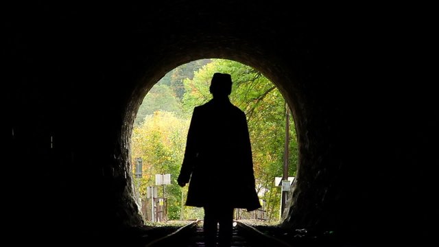 Woman walks towards light symbol finding hope, way out exit