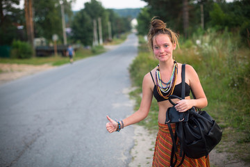 Young cute girl stops the car near the road. Hitchhiking.