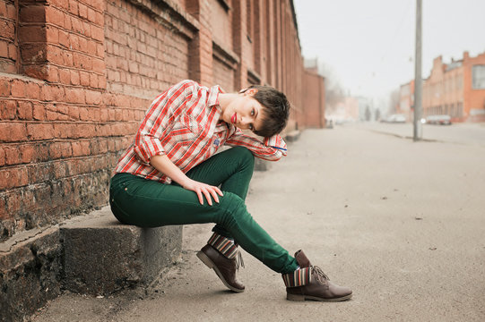 Woman wearing checkered shirt and jeans. Short hair