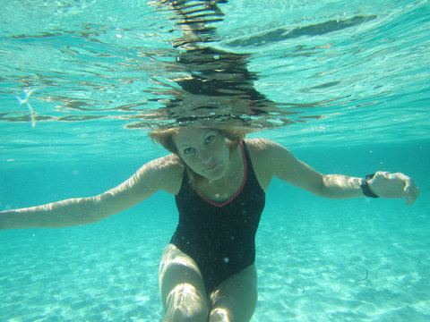 Female with eyes open underwater in ocean