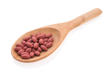 Pill on spoon isolated on white background