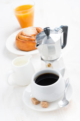 breakfast with coffee, sweet bun, cream and orange juice