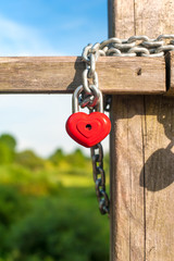 Love heart shape lock with chain on wooden bridge.