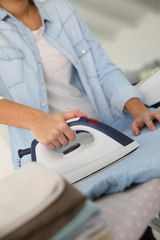 Fototapeta premium Closeup of woman ironing clothes on ironing board