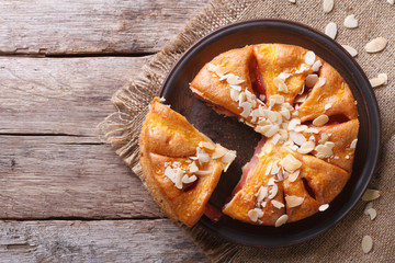 Tasty cutting almond pear pie closeup top view of the horizontal