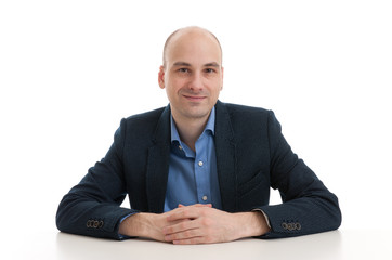 handsome bald man sitting at the desk