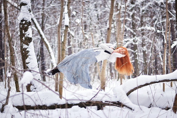 Beautiful girl sleeps in the air in the winter forest