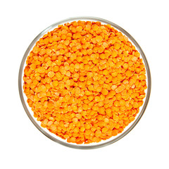Red lentile seeds in glass bowl isolated on white from above