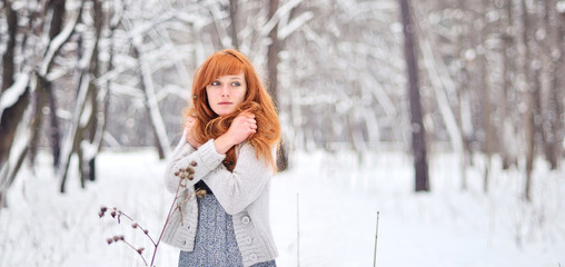 Beautiful red-haired girl in a snowy forest