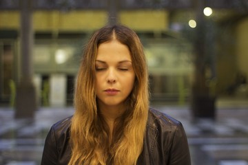 portrait outdoor of a blonde girl with closen eyes