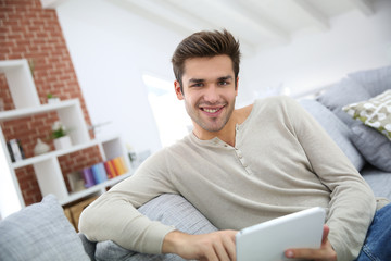 Man sitting in couch and websurfing on internet