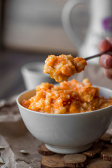 eating pumpkin millet porridge with milk, hands, breakfast