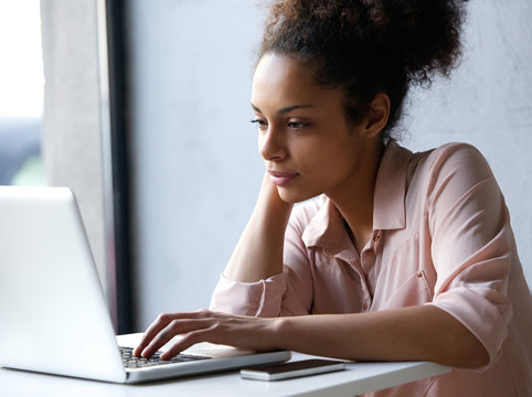 Young Black Woman Looking At Laptop