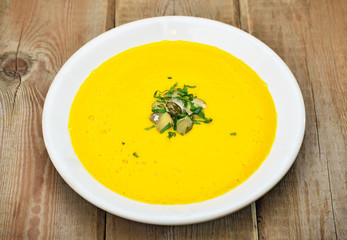Pumpkin soup on rustic wooden table