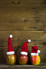 Weihnachtskarte: Holz Hintergrund mit Äpfel und Nikolausmützen