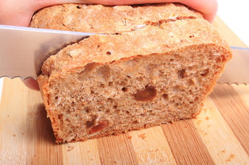 Hand of woman slicing fresh baked bread