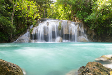 Fototapeta na wymiar Waterfall, green forest in Erawan National Park, Thailand. Landscape with water flow, river, stream and rock at outdoor. Beautiful scenery of nature for tourist to tour, visit, relax in vacation.