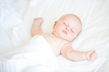 Peaceful newborn baby lying on a bed sleeping