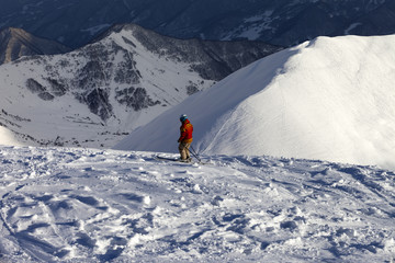 Fototapeta na wymiar Skier on off-piste slope in sun evening