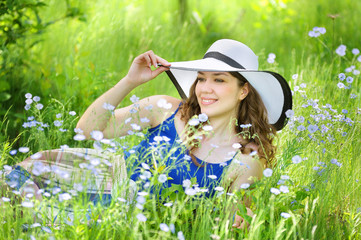 Portrait of a girl who is lying in the grass among flowers in a