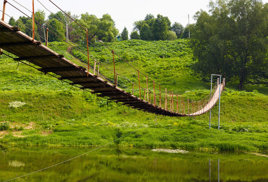 Pedestrian suspension bridge of steel - Powered by Adobe