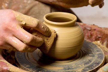 hands of a potter, creating an earthen jar