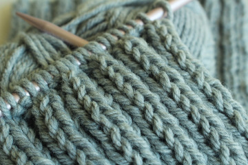 Fototapeta na wymiar Knitting project with gray yarn and pink needles