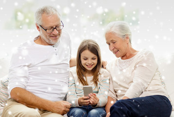 smiling family with smartphone at home
