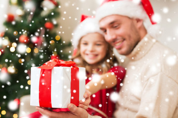 smiling father and daughter holding gift box