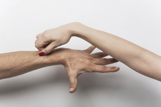 Woman's hand pinching man's arm