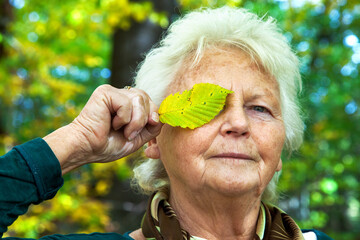 Senior woman holding sheet in front of the eye