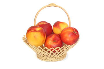 Nectarines in wicker basket isolated on white