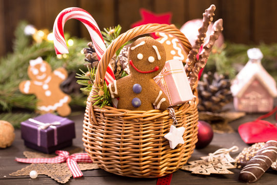 Basket of various Christmas treats, gingerbread man on the table
