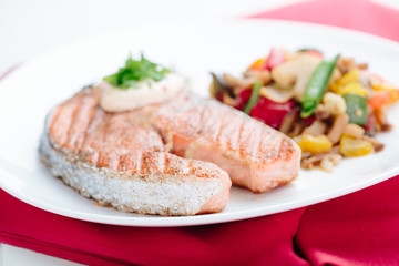 Grilled Salmon with Fresh vegetables on red background