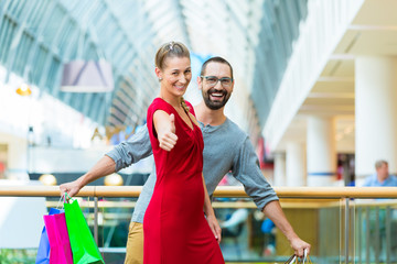 Mann und Frau in Kaufhaus mit Einkaufstüten