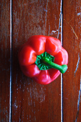 Red pepper on wood background, close up