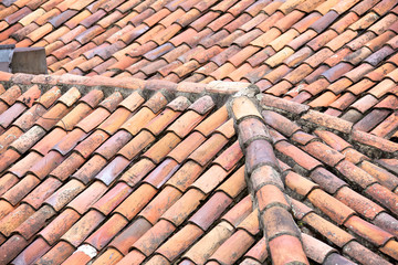 Close up of old and weathered red roof tiles