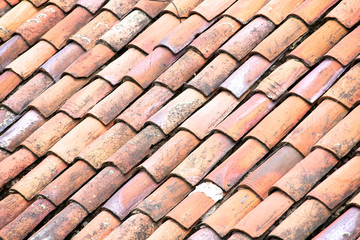 Close up of old and weathered red roof tiles
