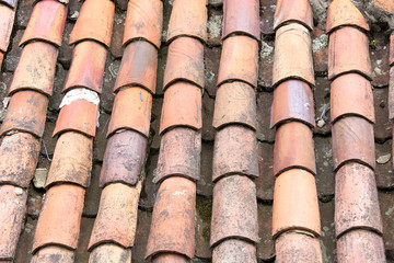 Close up of old and weathered red roof tiles